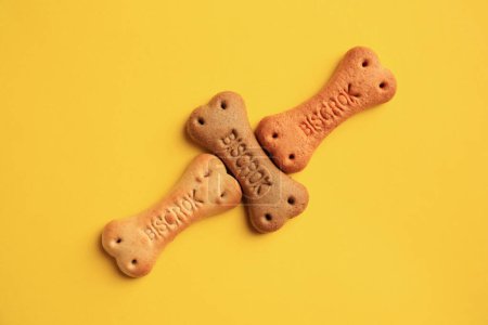 Téléchargez les photos : Bone shaped dog cookies on yellow background, flat lay - en image libre de droit
