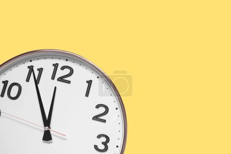 Photo for Clock showing five minutes until midnight on yellow background, top view with space for text. New Year countdown - Royalty Free Image