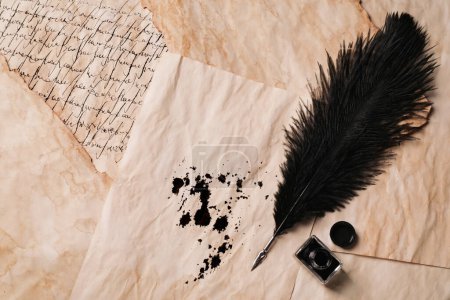 Téléchargez les photos : Open inkwell and lush feather pen on vintage parchments, flat lay. Space for text - en image libre de droit