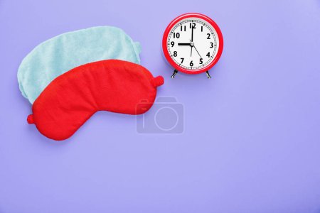 Photo for Soft sleep masks and alarm clock on purple background, flat lay. Space for text - Royalty Free Image