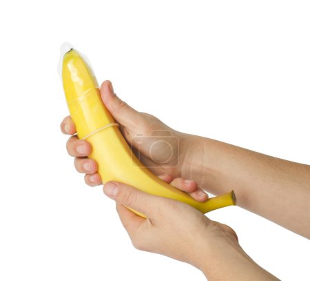 Téléchargez les photos : Femme tenant une banane en préservatif sur fond blanc, gros plan. Concept de sexe sûr - en image libre de droit
