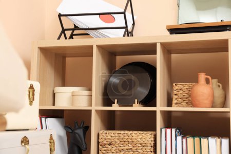 Téléchargez les photos : Wooden shelving unit with vinyl records near beige wall indoors - en image libre de droit