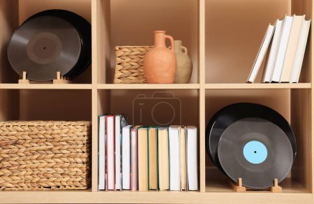 Téléchargez les photos : Wooden shelving unit with vinyl records near beige wall indoors - en image libre de droit