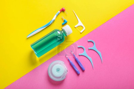 Foto de Flat lay composition with dental floss and different teeth care products on color background - Imagen libre de derechos