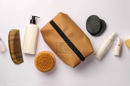 Photo for Compact toiletry bag, cosmetic products, comb and spa stones on white background, flat lay - Royalty Free Image