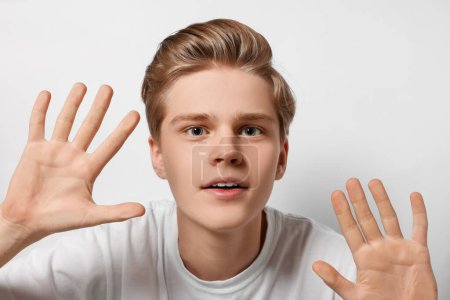 Téléchargez les photos : Excited teenage boy stuck to transparent screen - en image libre de droit