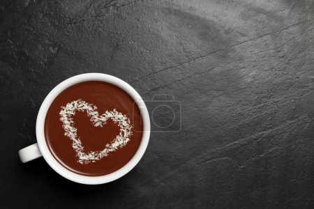 Téléchargez les photos : Coupe de chocolat chaud avec décoration en forme de coeur sur table noire, vue de dessus. Espace pour le texte - en image libre de droit