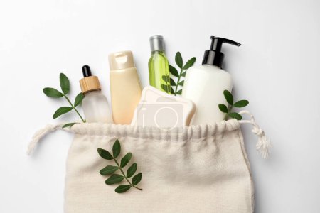 Photo for Preparation for spa. Compact toiletry bag, twigs and cosmetic products on white background, flat lay - Royalty Free Image