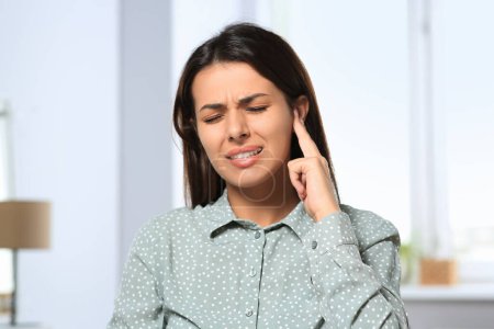 Téléchargez les photos : Young woman suffering from ear pain indoors - en image libre de droit