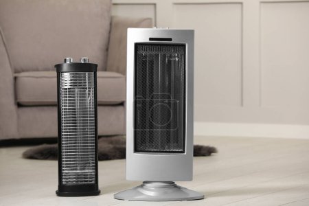 Diferentes calentador de infrarrojos modernos en el suelo en habitación acogedora