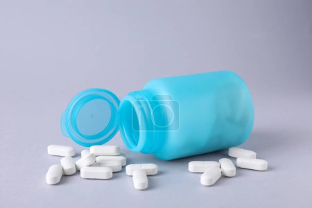 Antidepressants and medical jar on light grey background