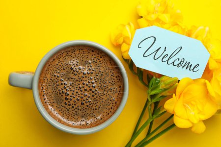 Téléchargez les photos : Welcome card, beautiful freesia flowers and cup of aromatic coffee on yellow background, flat lay - en image libre de droit
