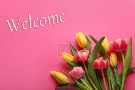 Téléchargez les photos : Carte de bienvenue. Belles fleurs de tulipes et mot sur fond rose, vue de dessus - en image libre de droit