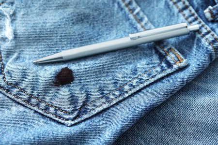 Téléchargez les photos : Pen and stain of black ink on jeans, closeup - en image libre de droit