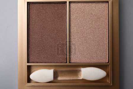 Photo for Beautiful eyeshadow palette with applicator on light gray background, top view. Professional cosmetic product - Royalty Free Image