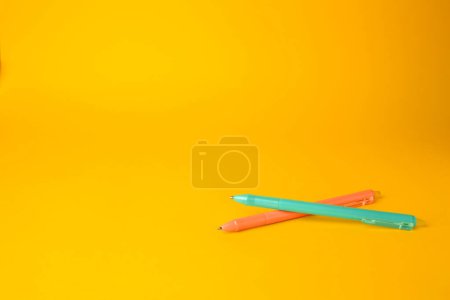 Photo for Two erasable pens on yellow background. Space for text - Royalty Free Image