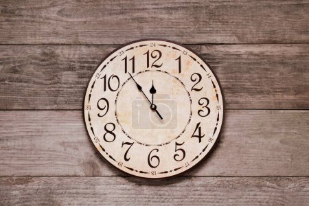Photo for Clock showing five minutes until midnight on wooden table, top view. New Year countdown - Royalty Free Image