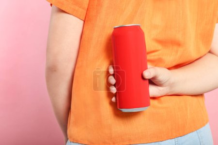 Foto de Mujer sosteniendo lata de bebida roja sobre fondo rosa, primer plano - Imagen libre de derechos
