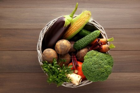 Téléchargez les photos : Panier avec différents légumes frais mûrs sur table en bois, vue sur le dessus. Produits agricoles - en image libre de droit