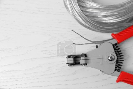 Photo for Professional cutters and cable with stripped wire on white wooden table, flat lay. Space for text - Royalty Free Image