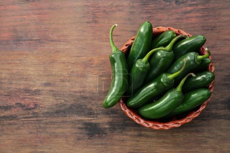 Photo for Bowl with green jalapeno peppers on wooden table, top view. Space for text - Royalty Free Image