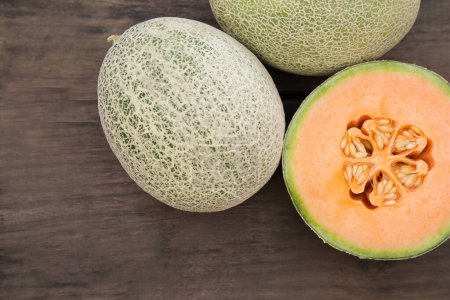 Photo for Whole and cut fresh ripe melons on wooden table, flat lay - Royalty Free Image