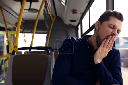 Téléchargez les photos : Sleepy tired man yawning in public transport - en image libre de droit