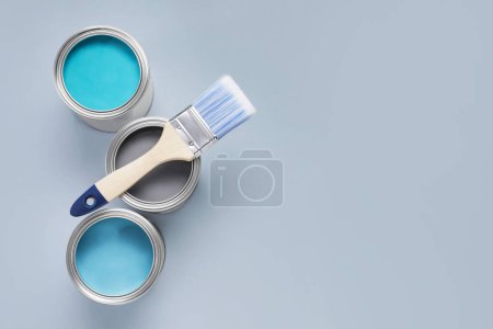 Photo for Cans with different paints and brush on light background, flat lay. Space for text - Royalty Free Image