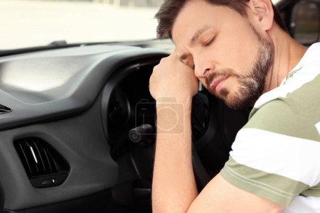 Hombre cansado durmiendo en su coche moderno, primer plano