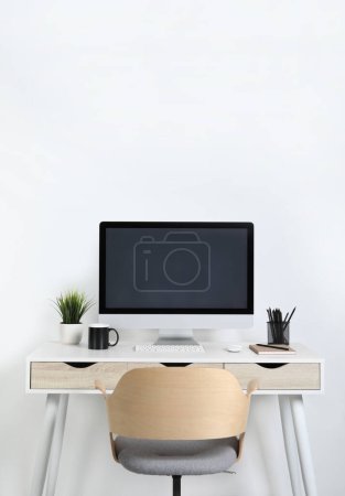 Cozy workspace with computer, houseplant and stationery on wooden desk at home Poster 644824044