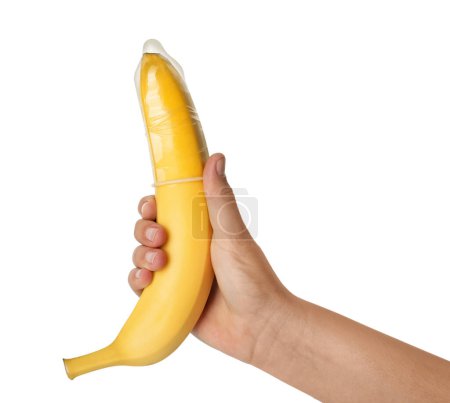 Téléchargez les photos : Femme tenant une banane en préservatif sur fond blanc, gros plan. Concept de sexe sûr - en image libre de droit
