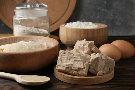 Verschiedene Arten von Hefe, Eiern, Mehl und Teig auf Holztisch