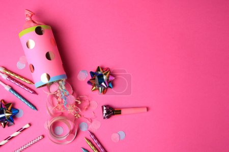 Photo for Party cracker and different festive items on bright pink background, flat lay. Space for text - Royalty Free Image