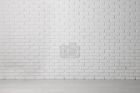 Téléchargez les photos : Beau mur de briques blanches et plancher en bois dans une pièce vide propre - en image libre de droit