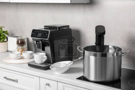 Téléchargez les photos : Pot avec cuisinière sous vide dans la cuisine. Cirateur d'immersion thermique - en image libre de droit