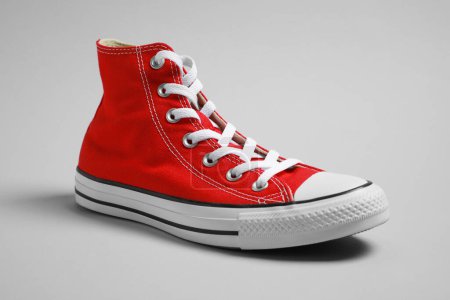 Téléchargez les photos : Une nouvelle sneaker rouge élégante sur fond gris clair - en image libre de droit
