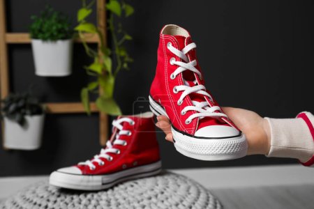 Woman with new stylish red sneakers indoors, closeup