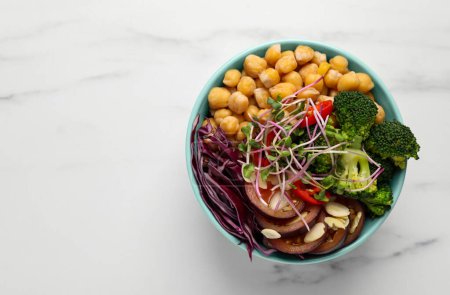 Photo for Delicious vegan bowl with broccoli, red cabbage and chickpeas on white marble table, top view. Space for text - Royalty Free Image