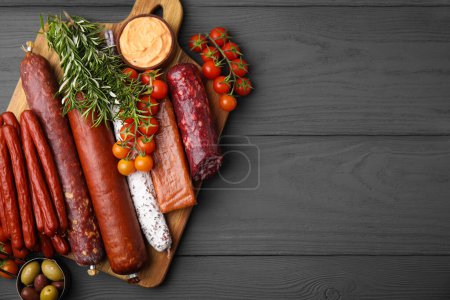 Photo for Different types of tasty sausages on grey wooden table, flat lay. Space for text - Royalty Free Image