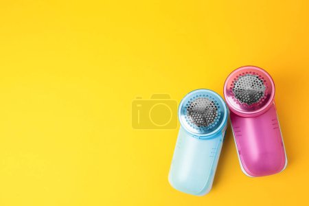 Photo for Modern fabric shavers on yellow background, flat lay. Space for text - Royalty Free Image