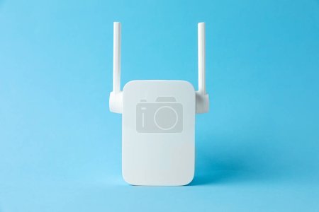 Foto de Nuevo repetidor Wi-Fi moderno sobre fondo azul claro - Imagen libre de derechos