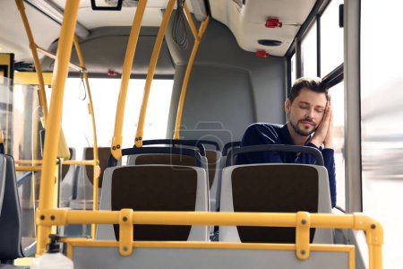 Téléchargez les photos : Homme fatigué dormant dans les transports en commun - en image libre de droit