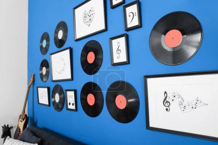 Photo for Vinyl records and different pictures on blue wall in living room - Royalty Free Image