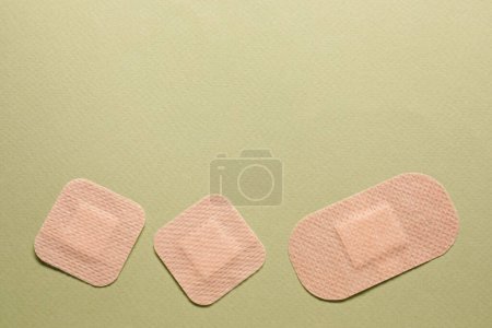 Photo for Different contraceptive patches on green background, flat lay. Space for text - Royalty Free Image