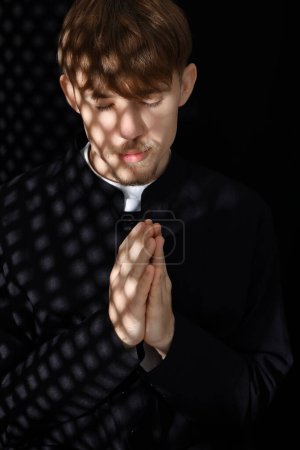 Téléchargez les photos : Prêtre catholique en soutane priant en confessionnal - en image libre de droit