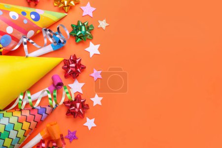 Flat lay composition with accessories for birthday party on orange background. Space for text