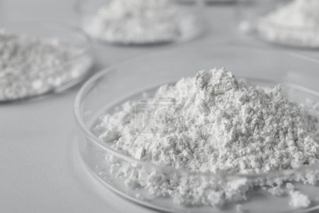 Petrischalen mit Calciumcarbonat-Pulver auf weißem Tisch, Nahaufnahme