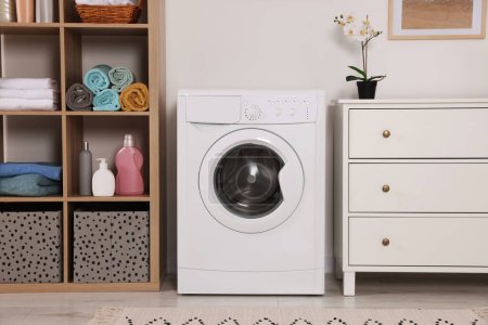 Foto de Elegante lavadero con lavadora y cómoda. Diseño de interiores - Imagen libre de derechos