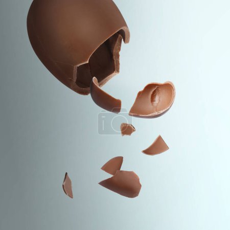 Photo for Exploded milk chocolate egg on color background - Royalty Free Image