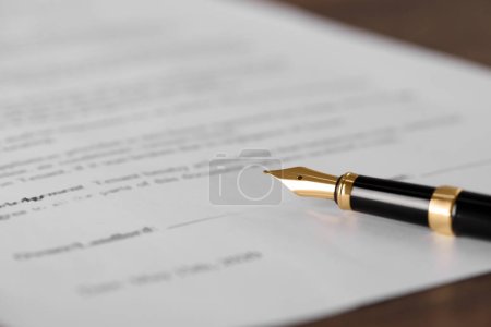 Photo for Fountain pen and document with place for signature on wooden table, closeup and space for text. Notary contract - Royalty Free Image